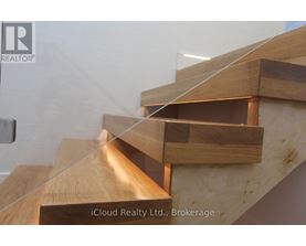 A wooden staircase with glass balustrade.