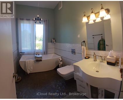A bathroom with a tub, toilet, and sink.