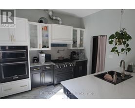 A kitchen with white cabinets and a black countertop.