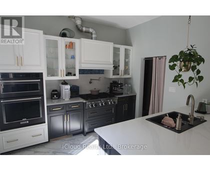 A kitchen with white cabinets and a black countertop.