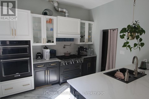 A kitchen with white cabinets and a black countertop.