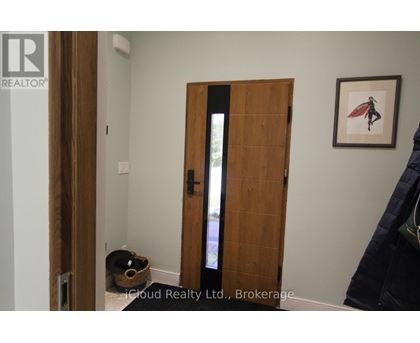 A room with a wooden door and a picture on the wall.