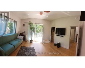 A living room with a green couch and a flat screen TV.