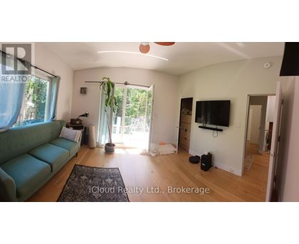 A living room with a green couch and a flat screen TV.