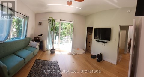 A living room with a green couch and a flat screen TV.
