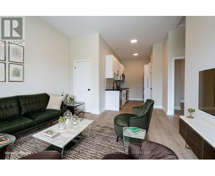 A living room with a green couch and a glass coffee table.