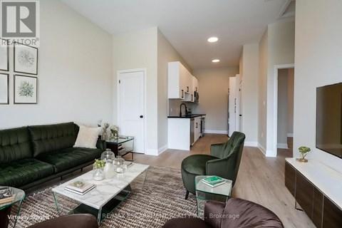 A living room with a green couch and a glass coffee table.