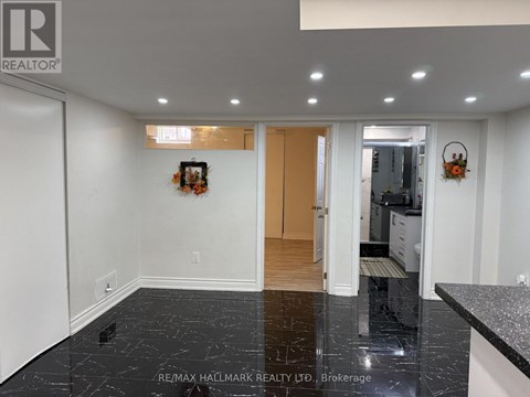 A black marble floor in a white room with a wooden door.