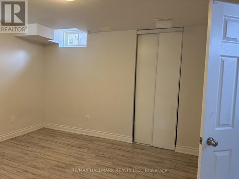 A room with a white door and a window on the ceiling.
