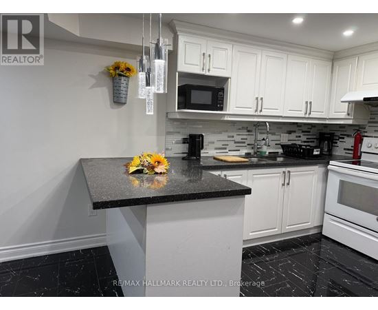 A kitchen with a black granite countertop and white cabinets.