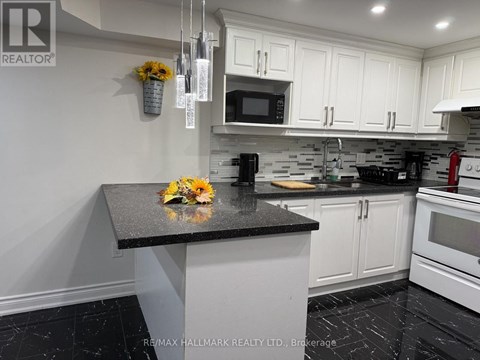 A kitchen with a black granite countertop and white cabinets.