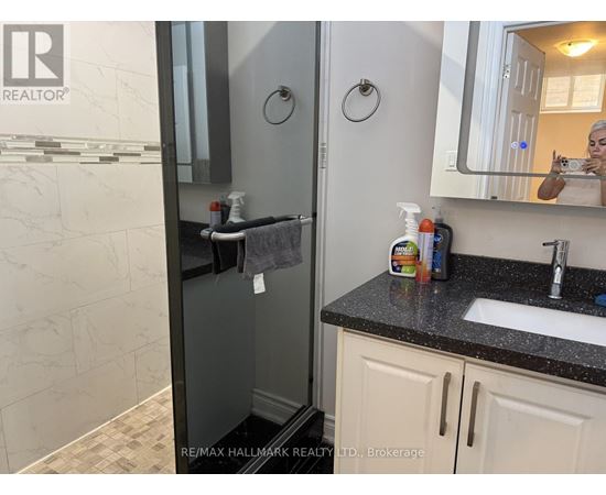 A bathroom with a sink, mirror, and toiletries.