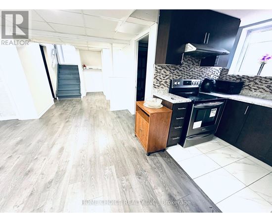 A kitchen with a wooden cabinet and a black fridge.