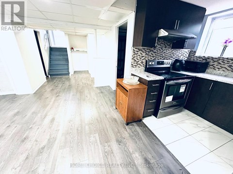 A kitchen with a wooden cabinet and a black fridge.