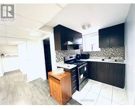 A kitchen with black cabinets and a wooden island.