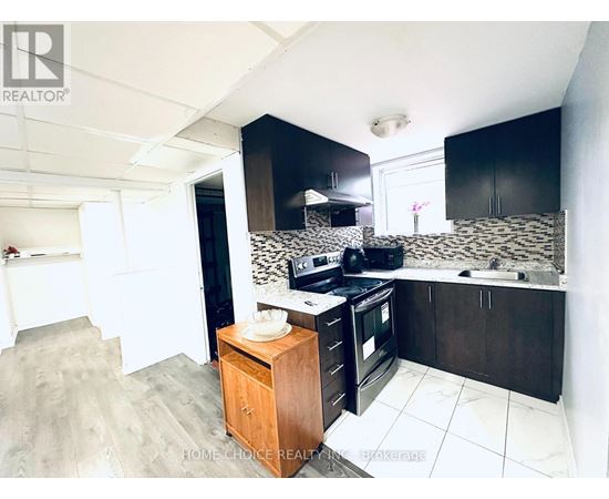 A kitchen with black cabinets and a wooden island.