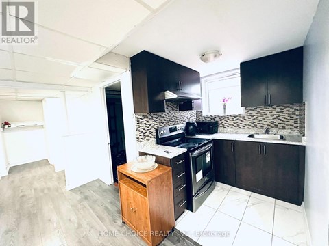 A kitchen with black cabinets and a wooden island.