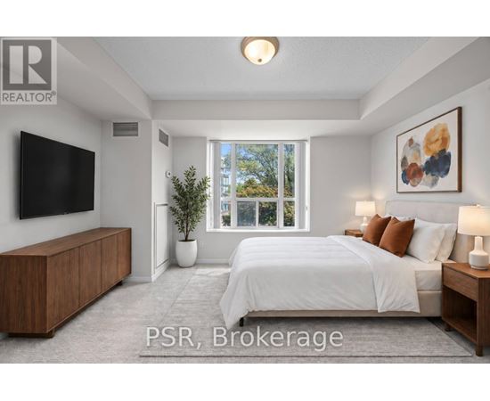 A bedroom with a large bed, a flat screen TV, and a window with a view of trees outside.