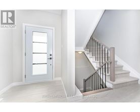 A staircase with a black railing and a white door.