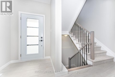 A staircase with a black railing and a white door.