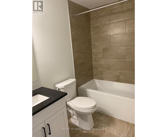 A bathroom with a toilet, sink, and bathtub.