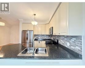 A kitchen with a granite countertop and stainless steel appliances.