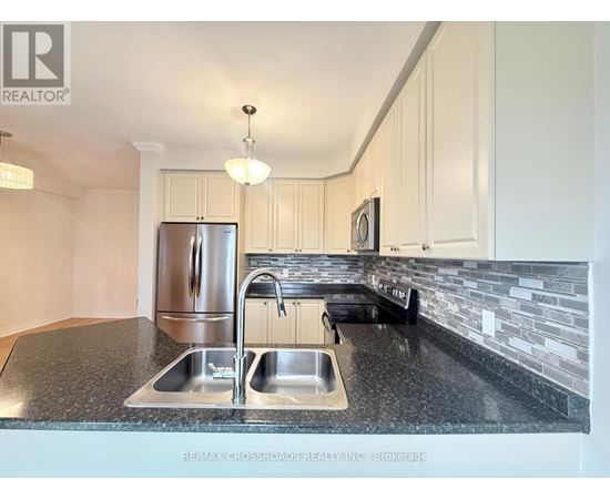 A kitchen with a granite countertop and stainless steel appliances.