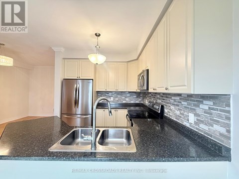 A kitchen with a granite countertop and stainless steel appliances.