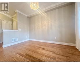 A room with wooden flooring and a chandelier.