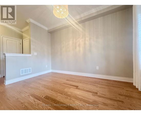 A room with wooden flooring and a chandelier.