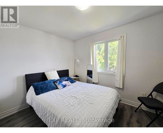 A bedroom with a bed, chair, and window.