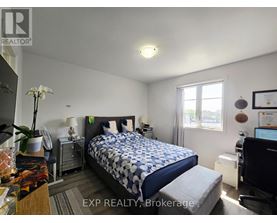 A bedroom with a bed, nightstand, and a window.