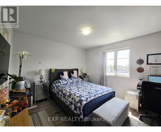 A bedroom with a bed, nightstand, and a window.
