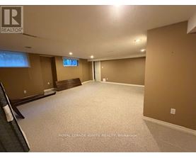 A spacious room with a carpeted floor and a window with blinds.