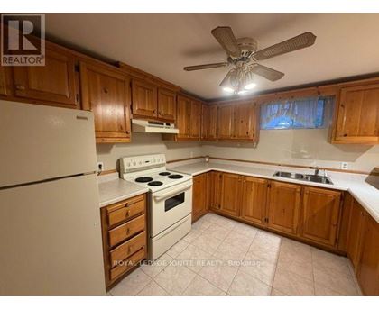 A kitchen with wooden cabinets and a white refrigerator.