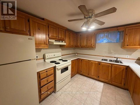 A kitchen with wooden cabinets and a white refrigerator.