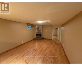A room with wooden flooring and a flat screen TV mounted on the wall.