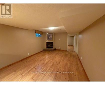 A room with wooden flooring and a flat screen TV mounted on the wall.