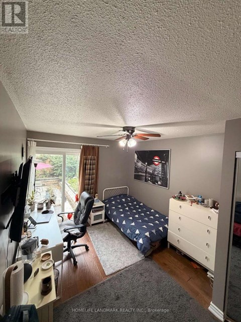 A bedroom with a bed, desk, and chair.