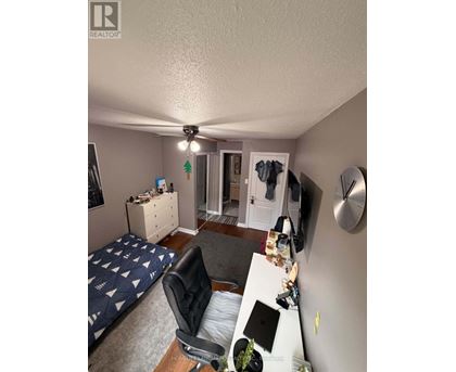 A bedroom with a bed, desk, and chair.