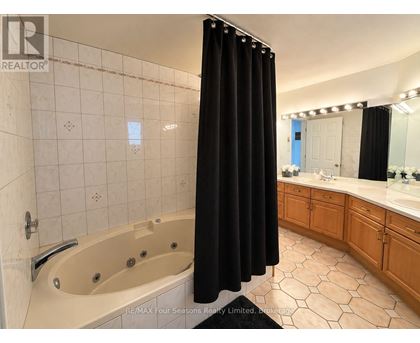 A bathroom with a black shower curtain and a bathtub.