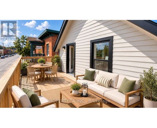 A white house with a wooden deck and patio furniture.