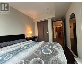 A bedroom with a large bed and a doorway leading to another room.