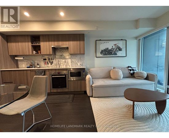 A modern kitchen with a glass table and a white sofa.