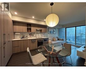 A modern kitchen with wooden cabinets and a glass table.