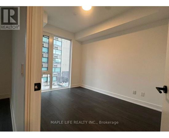 A room with a door and a window with a view of a city.