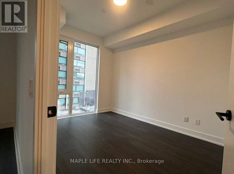 A room with a door and a window with a view of a city.