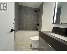A bathroom with a toilet, sink, and shower area.