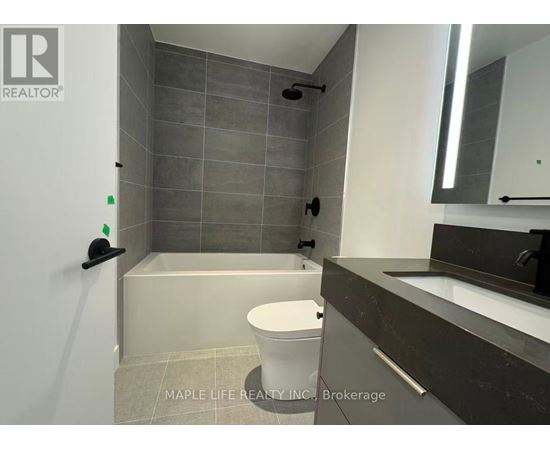 A bathroom with a toilet, sink, and shower area.
