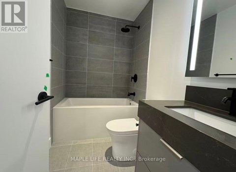 A bathroom with a toilet, sink, and shower area.